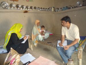 Benazir, R2HC Hygiene Promoter – Data Gatherer, conducts a session on personal hygiene for Abrab, 35, who has brought her son, Ajeeb, 12 months old, for follow-up at the CMAM site